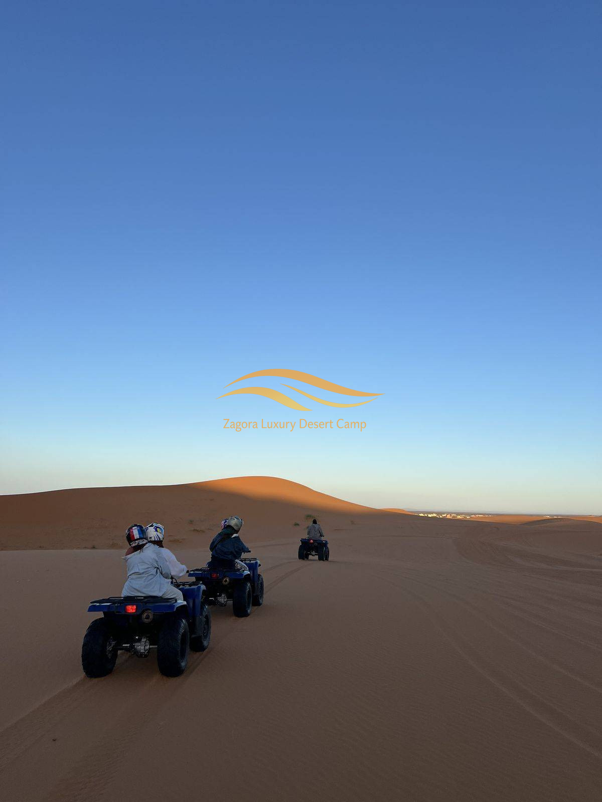 Quad biking adventure in Zagora Sahara Desert Morocco with travelers riding across sand dunes