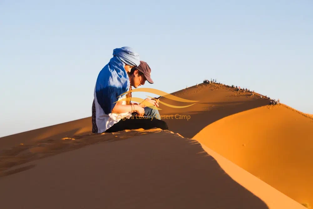 Couple enjoying the sand dunes on a 3-day private desert tour from Marrakech to Erg Chigaga